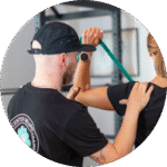 Therapeut assistiert Patientin bei einer Schulter-Übung